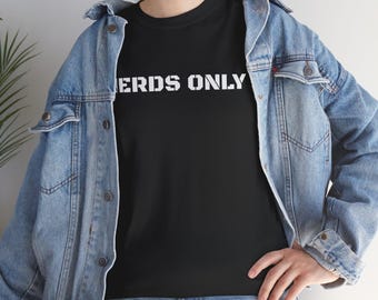 May include: Black t-shirt with the white text "NERDS ONLY". The shirt is being worn with a blue denim jacket and blue jeans.