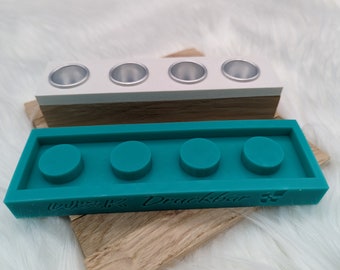 May include: Teal silicone mold with four round cavities, labeled "Washi Tape Druckbar". The mold is sitting on top of a wooden base with four small white cups.