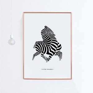 K&ouml;nnte beinhalten: Schwarz-wei&szlig;es abstraktes Kunst-Druck von zwei Zebras in einem geometrischen Muster. Der Druck ist in einem d&uuml;nnen, ros&eacute;goldenen Rahmen gerahmt. Der Name des K&uuml;nstlers, Victor Vasarely, ist unter dem Bild gedruckt.