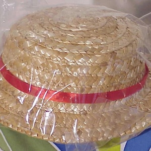 May include: A straw hat with a wide brim and a red ribbon around the crown.