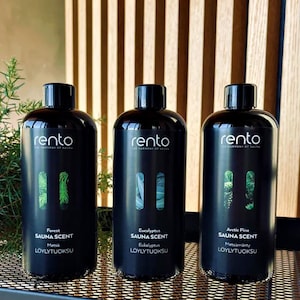 May include: Three black bottles of sauna scent with different scents: Forest, Eucalyptus, and Arctic Pine. Each bottle has a label with the scent name, the words "SAUNA SCENT", and the Finnish word "LÖYLYTUOKSU".