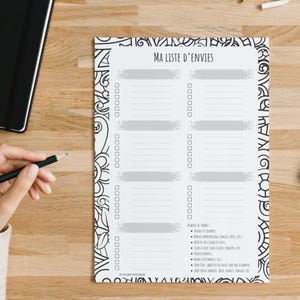 Peut inclure: Une liste de souhaits imprimable blanche avec une bordure à motifs noirs et blancs. La liste est intitulée "MA LISTE D'ENVIES" et comporte 10 lignes vierges avec des cases à cocher. Le bas de la liste comprend une section intitulée "EXEMPLES DE THEMES" avec une liste d'idées pour des choses à ajouter à la liste.