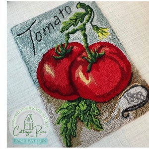 May include: A punch needle embroidery pattern featuring two red tomatoes with green leaves and stems. The pattern is titled "Tomato" and includes the text "1882".