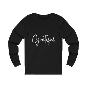 May include: Black long-sleeved shirt with the word "Grateful" written in white cursive script.