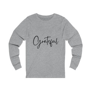 May include: Grey long-sleeved shirt with the word "Grateful" written in black cursive script.
