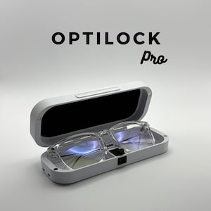 May include: A white Optilock Pro glasses case with a pair of clear-framed glasses inside. The case is open, revealing a black interior. The text "OPTILOCK Pro" is displayed in black above the case.
