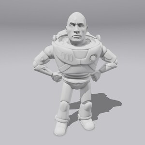 Op de afbeelding: Een wit 3D-geprint beeldje van een ruimte-ranger met een menselijk gezicht. Het beeldje staat met gekruiste armen en heeft een serieuze uitdrukking.