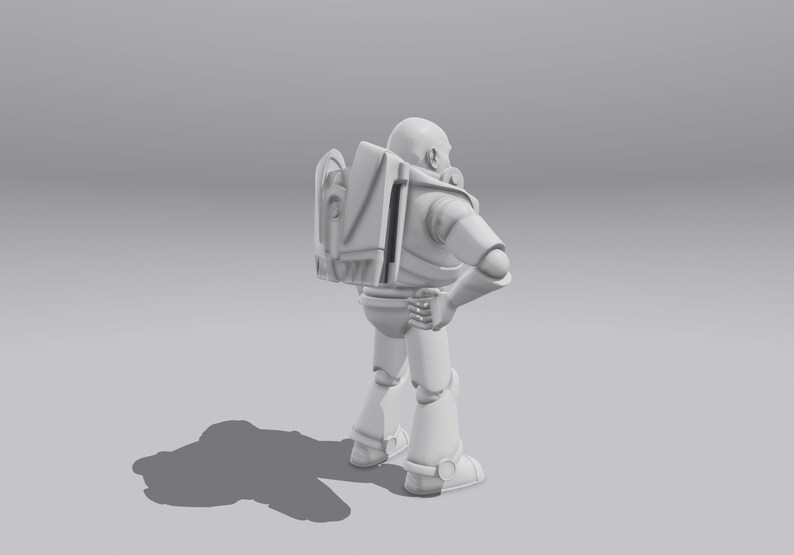 Op de afbeelding: Een wit plastic speelgoedrobot met een rugzak en een helm. De robot staat met zijn rechterarm gebogen in de elleboog en zijn linkerarm recht naar beneden. De robot kijkt naar rechts.