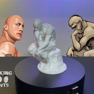 May include: A white 3D printed sculpture of the "Thinker" statue on a black turntable. The sculpture is on a white base. The words "ROCKING 3D PRINTS" are visible on the turntable.
