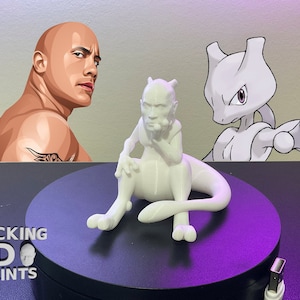 May include: A white 3D printed figurine of a Pokemon character sitting with its chin on its hand. The figurine is on a black turntable with the words "ROCKING 3D PRINTS" on the side.