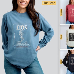 May include: A long-sleeved t-shirt with a vintage-style graphic of a lion with the text "UNLEASH THE LION INSIDE OF YOU" and "JOSHUA 1:9". The shirt is available in blue jean, crimson, ivory, and black.