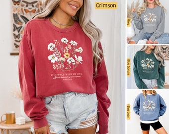 Puede incluir: Una sudadera roja, gris, verde y azul con un diseño floral y el texto "It is well with my soul. He has delivered my soul in peace. Psalm 46:10".