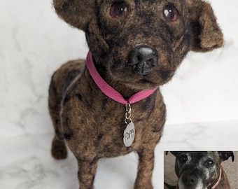 May include: A needle-felted dog figurine with dark brown and black mottled fur, floppy ears, and dark eyes. It wears a bright pink collar with a silver-toned oval tag engraved with the name Poppy. A small reference photo of a dog is included.