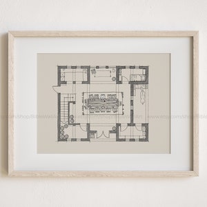 May include: A black and white line drawing of a floor plan for a house. The plan shows a large dining room with a long table and chairs, a kitchen, and a hallway. The drawing is on a beige background.