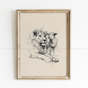 May include: Framed art print with a black line drawing of a lion and a lamb. The lion is recumbent, with the lamb standing beside it. The artwork is set against a beige backdrop and enclosed in a light brown frame.