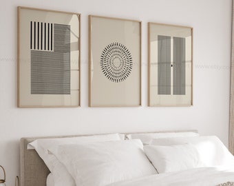 Puede incluir: Tres impresiones geométricas minimalistas en blanco y negro en marcos de madera en una pared blanca sobre una cama con ropa de cama blanca.