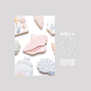 May include: A collection of shell-shaped cookies decorated with pastel icing, featuring various marine designs including starfish and coral. To the right, a white outline of a shell shape is displayed with the text SHELL A COOKIE CUTTER.