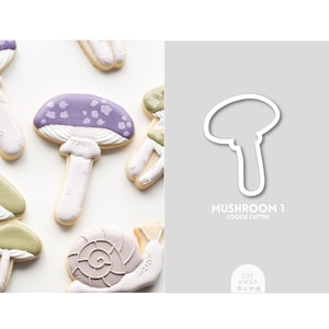 May include: A cookie cutter in the shape of a mushroom. The cutter is white and has a simple design. The text "Mushroom 1 Cookie Cutter" is printed below the cutter.