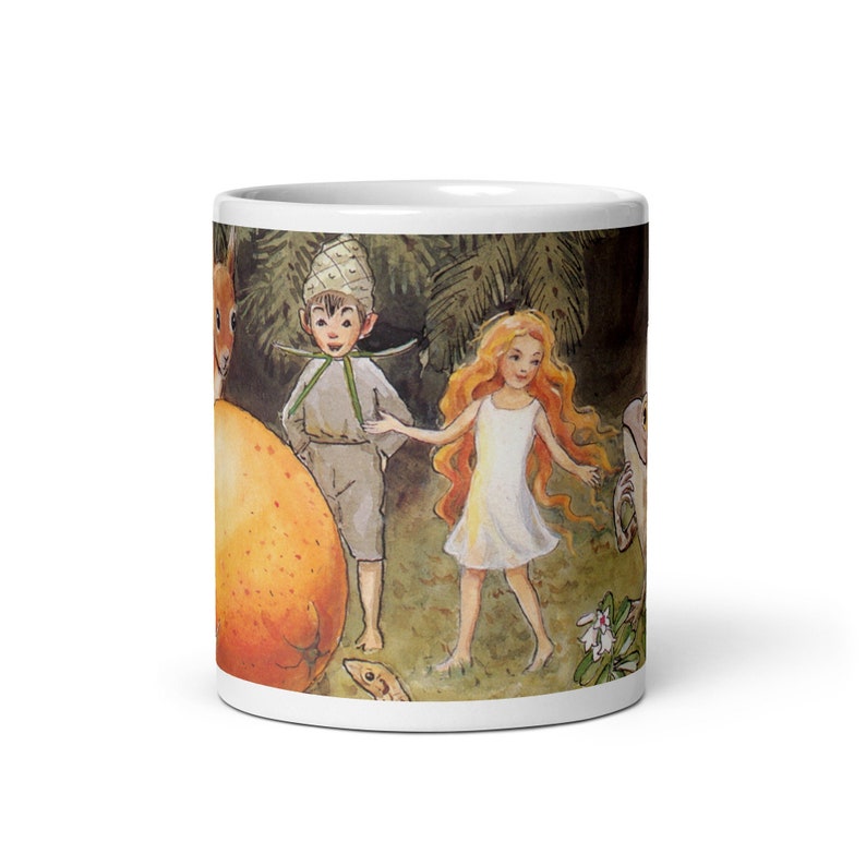 May include: A white ceramic mug with a colorful illustration of a fairy and a gnome in a forest setting. The illustration features a large orange fruit, green foliage, and a small white flower.