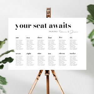 May include: A white seating chart with black text, titled "your seat awaits" with the date "10.20.2022" and the names "Eleanor & Jackson" in cursive. The chart lists guest names for each table number, from one to twelve.