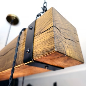 May include: A rustic wooden ceiling light fixture with black metal accents and exposed wiring. The fixture is made from reclaimed wood and has a natural finish.