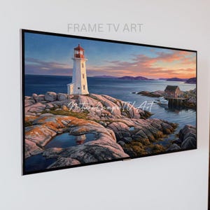 May include: A framed landscape painting of a lighthouse on a rocky coast at sunset. The lighthouse is white with a red top, set against a backdrop of a colorful sky and ocean. The text "FRAME TV ART" is at the top.