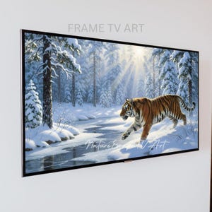 Könnte beinhalten: Ein gerahmtes TV-Kunstwerk zeigt eine Winterlandschaft mit einem Tiger. Das Kunstwerk zeigt einen verschneiten Wald, einen gefrorenen Fluss und Sonnenlicht. Der Text "FRAME TV ART" und "Nature Escape TV Art" sind sichtbar.