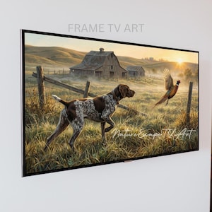 May include: A framed digital art piece depicting a hunting scene. A brown and white dog is in a field, chasing a pheasant. The background features a barn, fence, and a sunrise. The text "FRAME TV ART" is at the top.