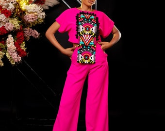 Peut inclure: Une tenue rose en deux pièces avec un haut court à motifs géométriques et un pantalon large.