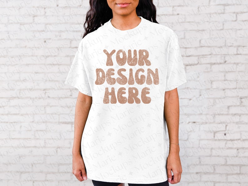May include: White t-shirt mockup with the text "YOUR DESIGN HERE" in brown letters with a distressed look.