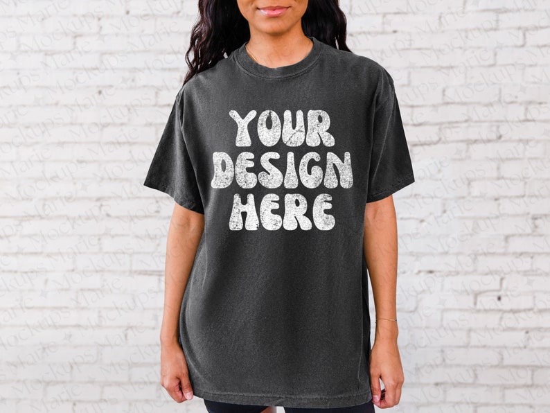 May include: A black t-shirt with a white graphic that says "YOUR DESIGN HERE" in a retro font.