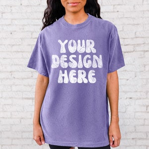 May include: A purple t-shirt with a white vintage-style graphic that says "YOUR DESIGN HERE".
