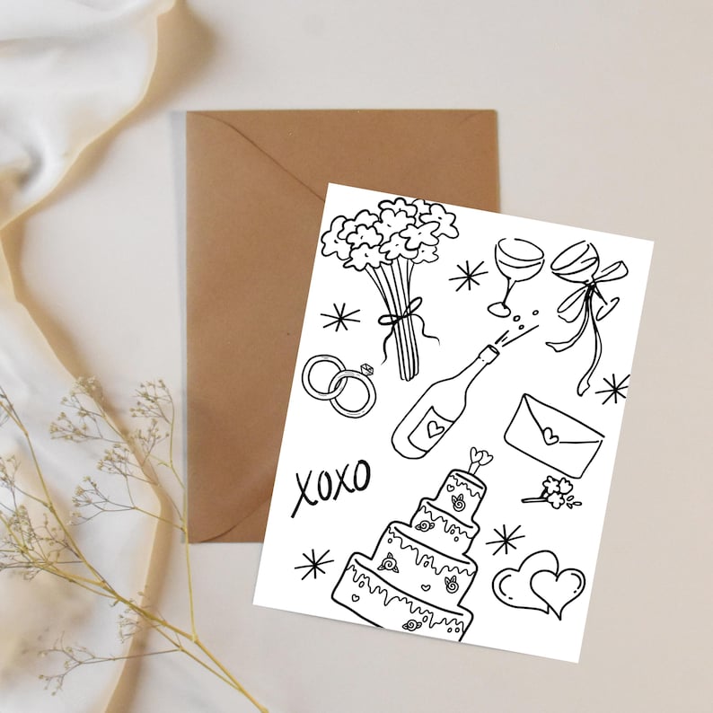Peut inclure: Illustration en noir et blanc sur le th&egrave;me du mariage, avec un g&acirc;teau &agrave; plusieurs &eacute;tages, une bouteille de champagne, des alliances et des fleurs. Le mot "xoxo" est &eacute;galement inclus. La carte est pos&eacute;e sur une surface blanche avec une enveloppe brune.