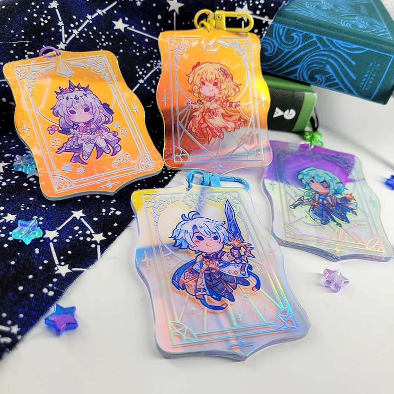 May include: Four clear acrylic keychains with anime-style illustrations. Each keychain features a different character in vibrant colors, set against a decorative background. The keychains have gold or blue clasps and are surrounded by star-shaped confetti.