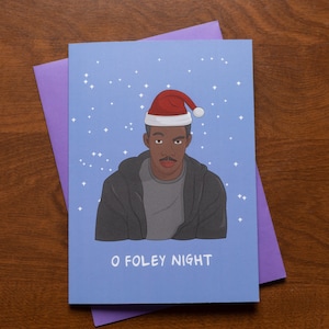 May include: A blue Christmas card with a man wearing a Santa hat and a black jacket. The card says "O Foley Night".