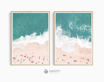 May include: Two framed prints of an aerial view of a beach with turquoise water and white waves crashing on the shore. The beach is covered with colorful umbrellas and people.