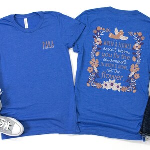 May include: A royal blue t-shirt with a floral design and the text "WHEN A FLOWER doesn't bloom you fix the environment IN WHICH IT GROWS, not the flower." printed on the back. The front of the shirt has the word "PARA" printed in a smaller font.