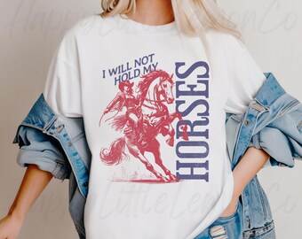 May include: White t-shirt with a red and blue graphic of a woman riding a horse. The text "I will not hold my horses" is printed on the shirt.
