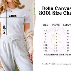 May include: Bella Canvas 3001 size chart with measurements in inches for XS, S, M, L, XL, 2XL, 3XL, and 4XL sizes. The chart shows the width and length of each size. The model is 5'4" and 120lbs and is wearing a size S.