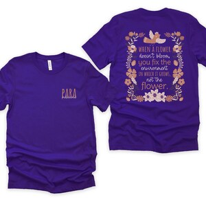 May include: Purple t-shirt with a floral design and the text "WHEN A FLOWER doesn't bloom you fix the environment IN WHICH IT GROWS, not the flower." on the back. The front of the shirt has the text "PARA" in a smaller font.