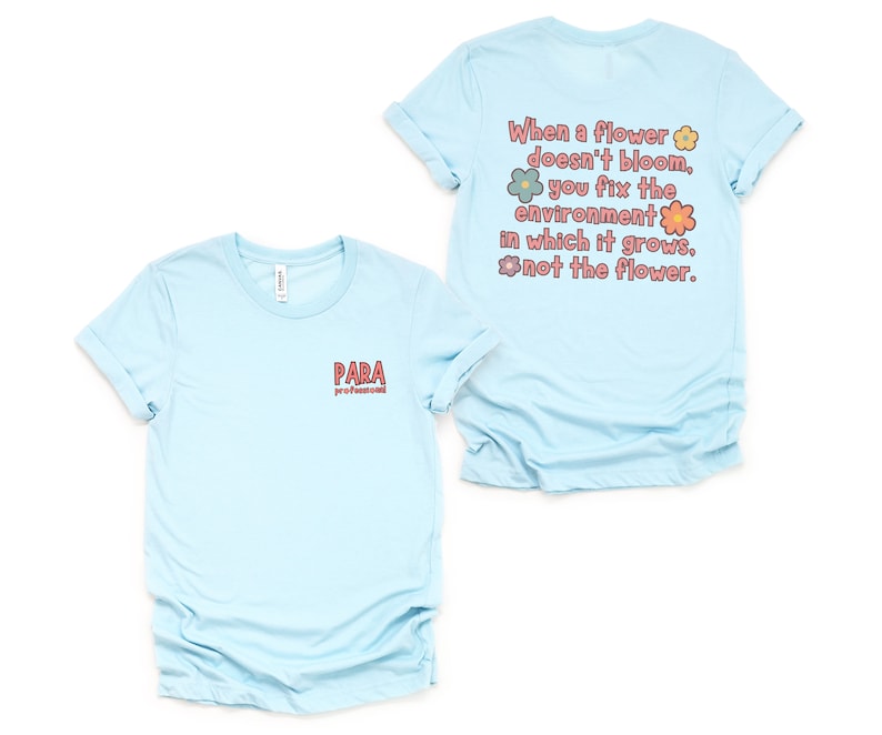 May include: Light blue t-shirt with a quote about flowers and the environment. The quote reads "When a flower doesn't bloom, you fix the environment in which it grows, not the flower." The text is surrounded by colorful flowers. The front of the shirt has the word "PARA" printed on it.