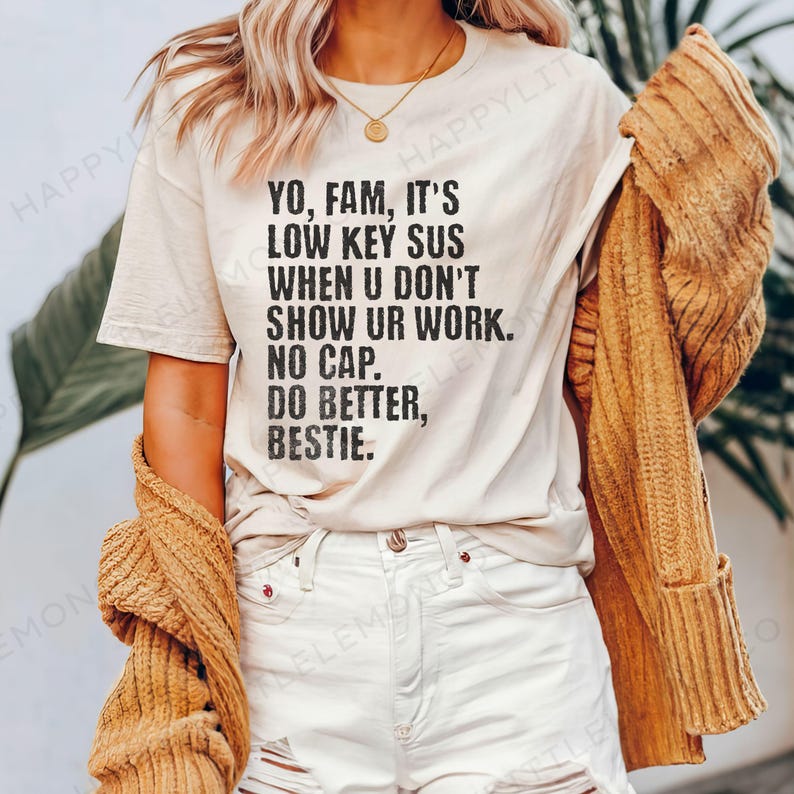 May include: A cream-colored t-shirt with black text that reads "YO, FAM, IT'S LOW KEY SUS WHEN U DON'T SHOW UR WORK. NO CAP. DO BETTER, BESTIE." The person is wearing white shorts and a mustard-colored cardigan.