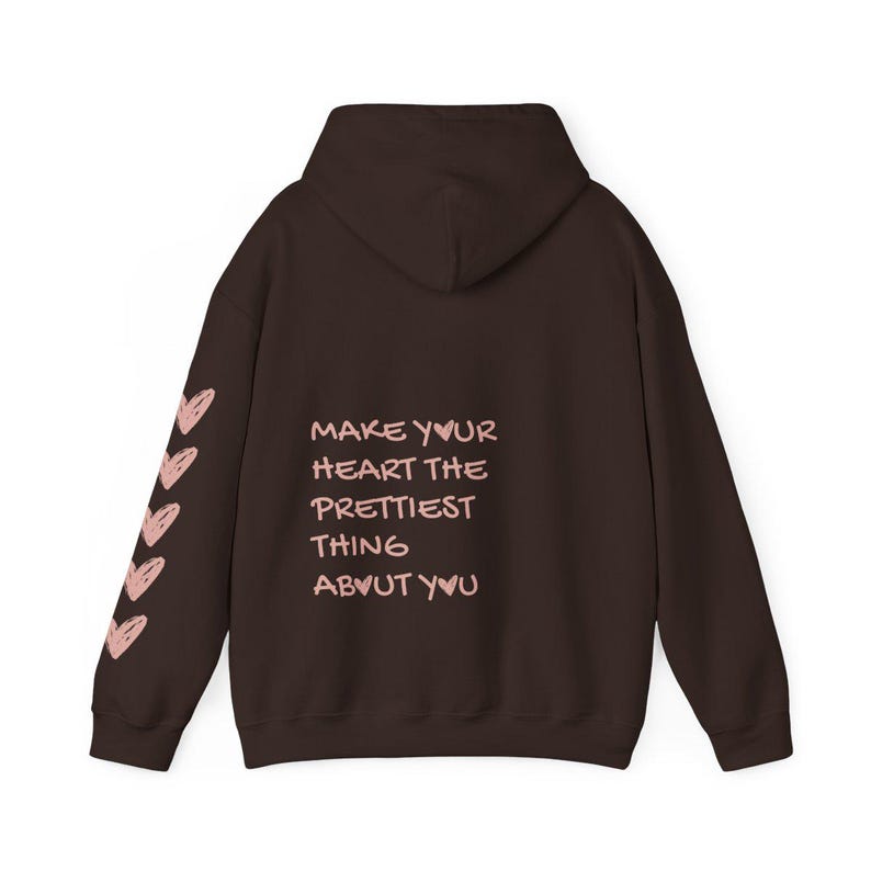 May include: A brown hoodie with a hood and long sleeves. The left sleeve has a series of pink hearts. The back of the hoodie has the text "MAKE YOUR HEART THE PRETTIEST THING ABOUT YOU" in pink.