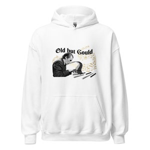 Puede incluir: Sudadera con capucha blanca con una imagen en blanco y negro de un hombre tocando un piano con el texto "Old but Gould" en letras negras.