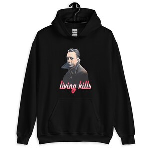 Peut inclure: Sweat-shirt à capuche noir avec un graphique d'un homme et le texte "living kills" en rose.
