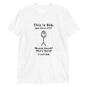 Può includere: Maglietta bianca con un'illustrazione in nero di un personaggio di nome Bob. Il testo dice "This is Bob. Bob has no arms." e "Knock Knock" Who's there? It isn't Bob."