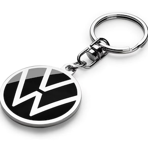 May include: A silver key ring with a black and white Volkswagen logo. The logo is a circle with a stylised "W" inside.