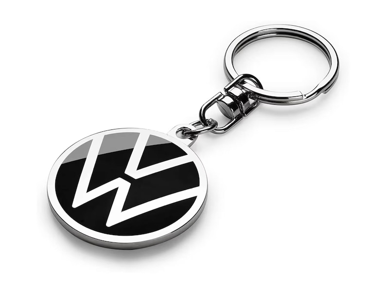 May include: A silver key chain with a black and white Volkswagen logo. The logo is a circle with a stylized "W" inside.
