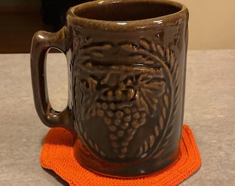 Brown Glazed stoneware mug featuring an embossed grape and vine trellis motif  4.75 inches in height 16 fluid ounces.