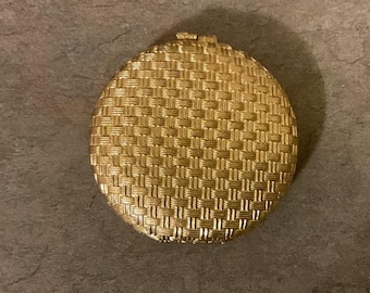 Vintage oval Revlon Love Pat Misty Rose powder compact in a gold tone finish with a woven basketweave pattern.